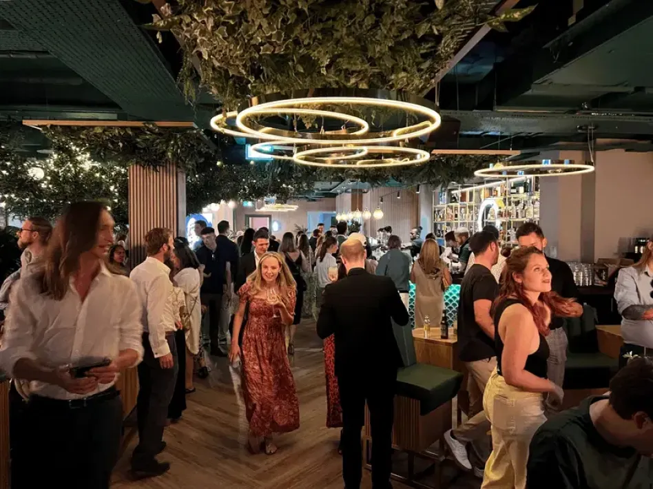 A full OCHE venue at night under its ring chandeliers
