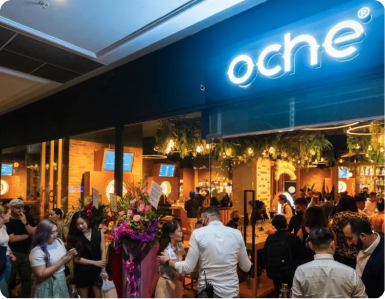 The illuminated OCHE frontage above a busy venue floor