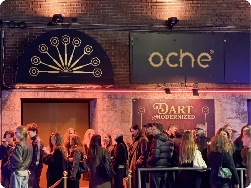 A queue outside an OCHE venue beneath the neon sign